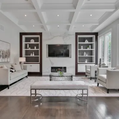 Formal living room with a coffered ceiling, built-in shelves and a fireplace wall