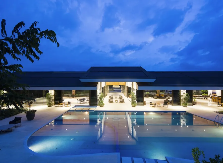 Hotel pool and open pavilion lit at dusk under a deep blue sky