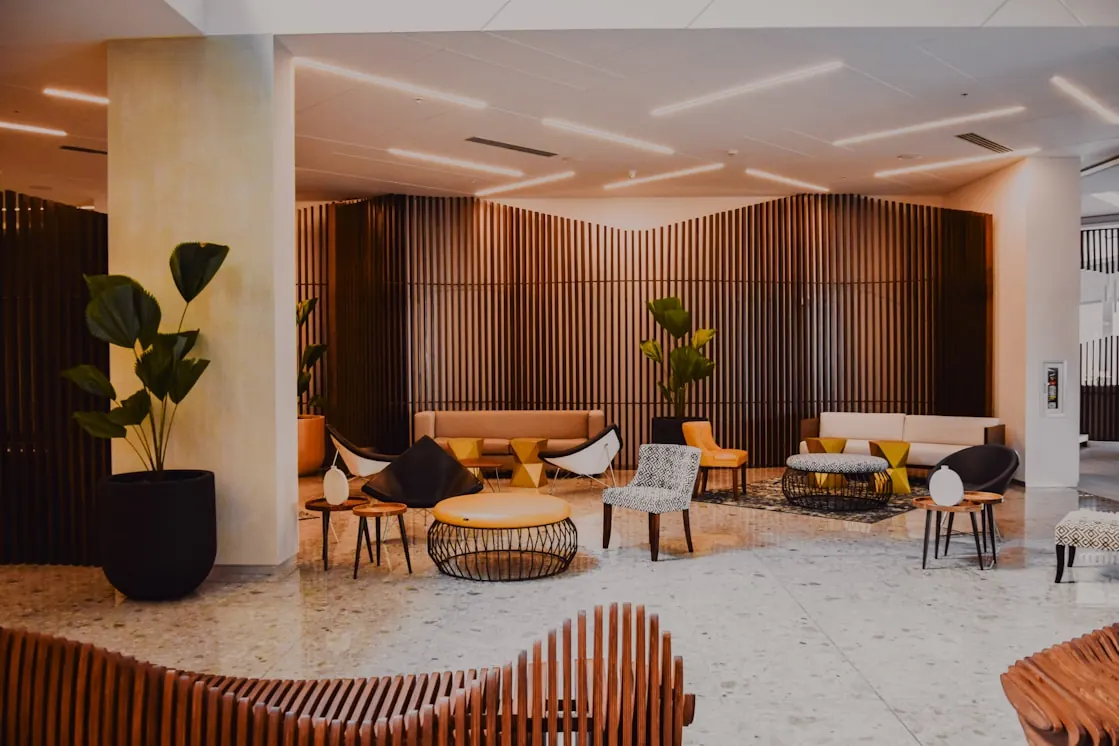 Hotel lobby lounge with timber slat wall, terrazzo floor and pendant seating