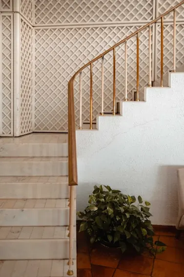 Staircase with a curved timber handrail and a lattice screen wall