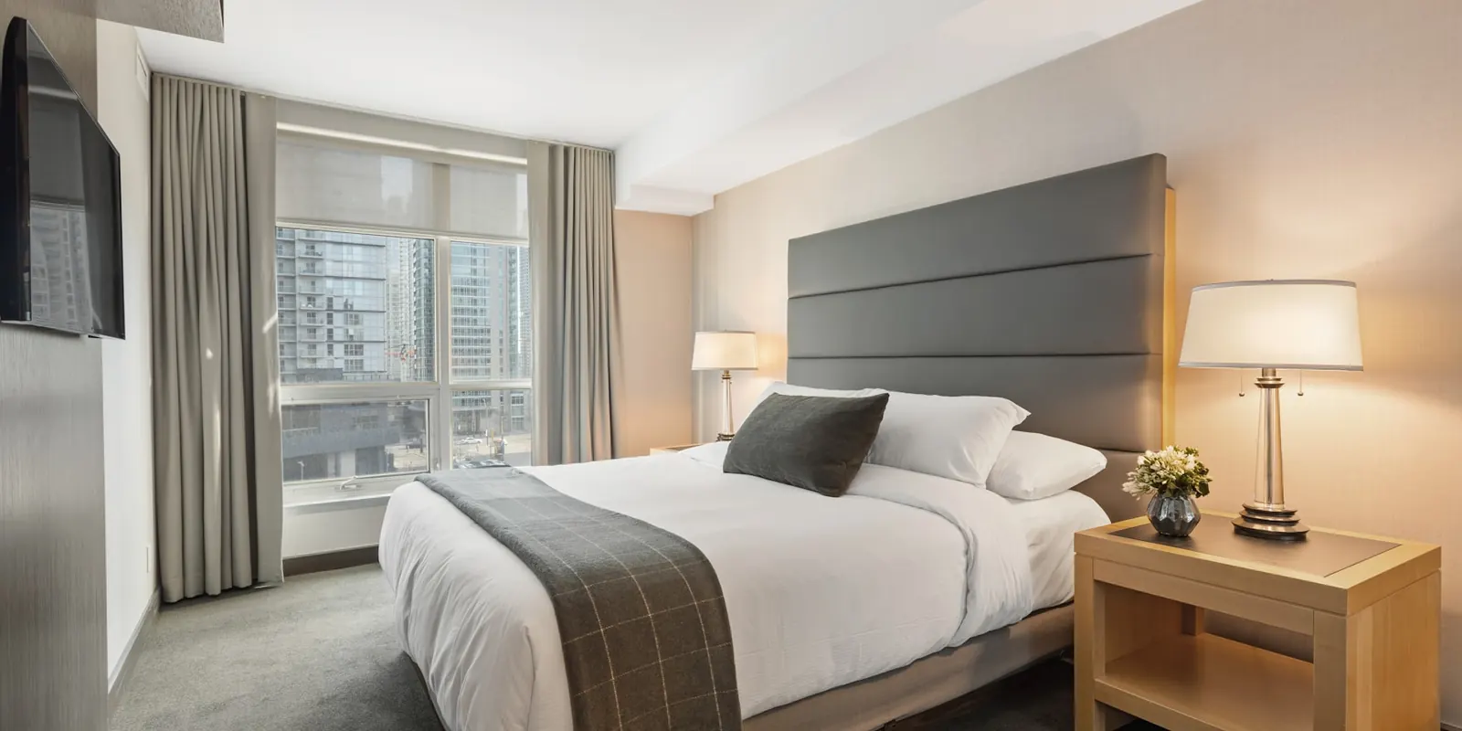 Calm bedroom with an upholstered headboard, linen bedding and warm lamplight